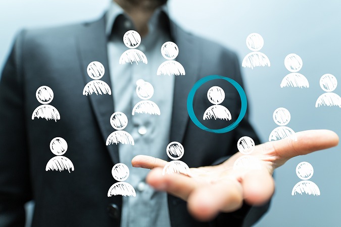ビジネスマンの手の上に浮かぶ人型アイコン