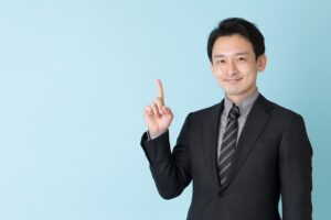 指を差すスーツ男性