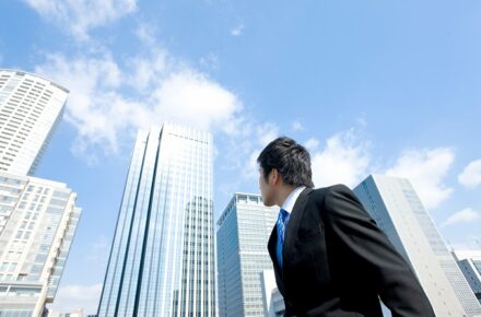 ビルを見上げるビジネスマン