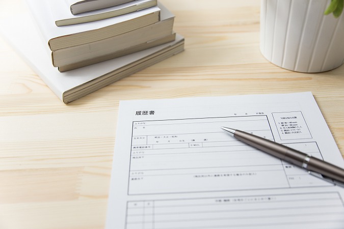 履歴書とペンと積まれた本